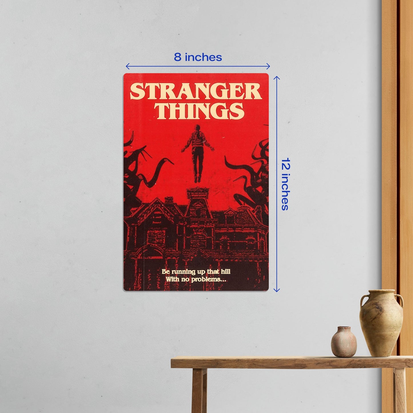 Small 8x12 inch Stranger Things Max Mayfield metal poster hanging on a clean white wall in a minimalist room setting.