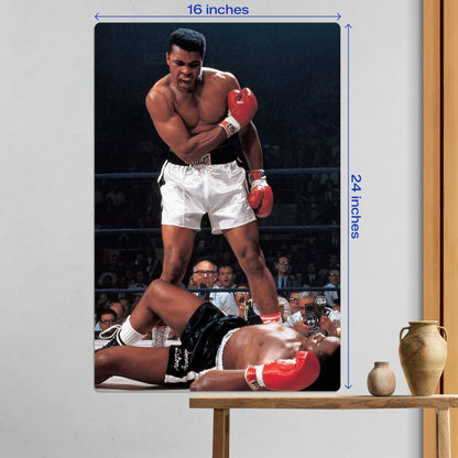 Large 16x24 inch Muhammad Ali boxing legend metal poster displayed as wall art above a wooden table with decorative vases.