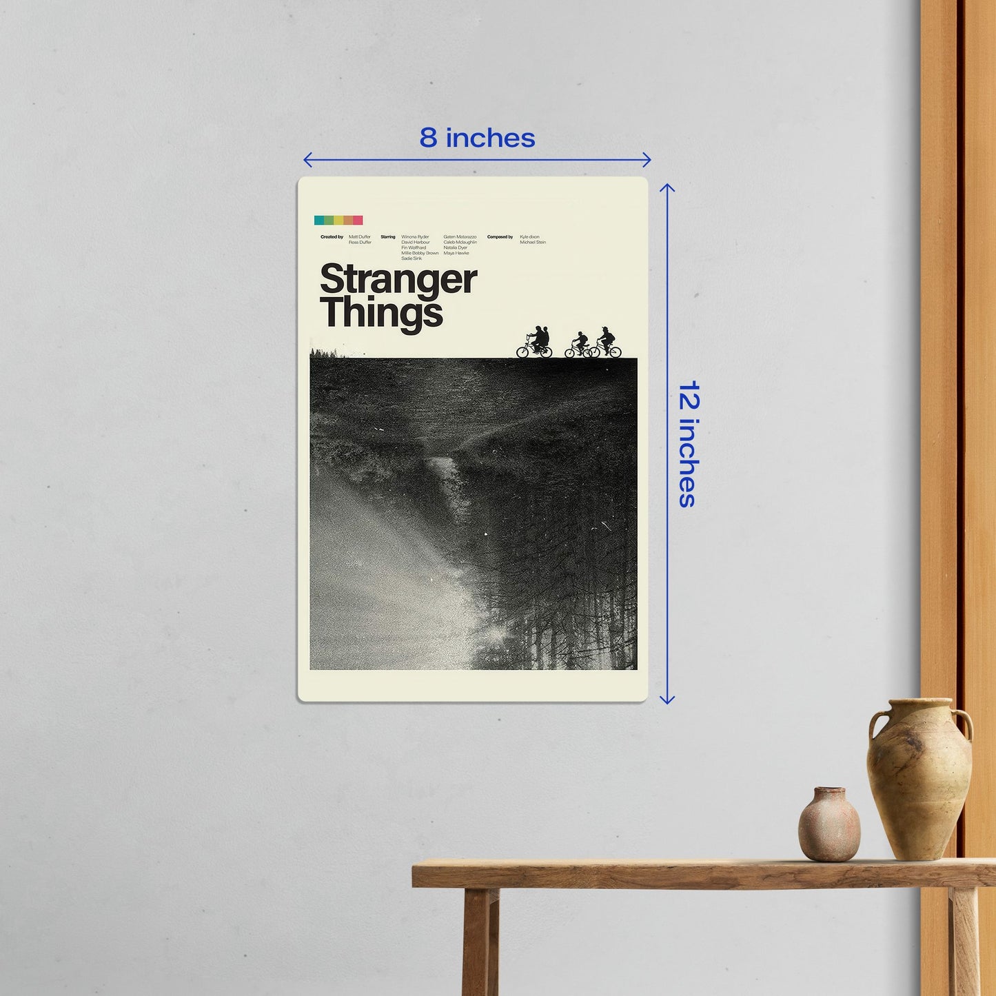 Small 8x12 inch Stranger Things minimalist metal poster hanging on a clean white wall in a modern home interior.